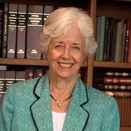 Person standing in front of bookshelf smiling